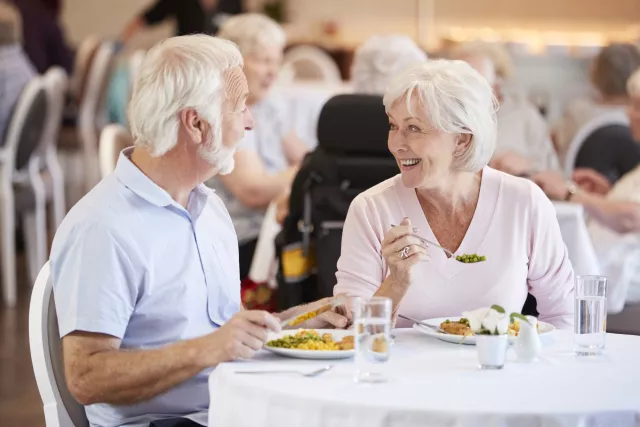 seniors à table, souriants, heureux de déjeuner